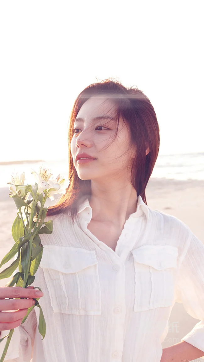 海边拿着花的清纯美女手机桌面1