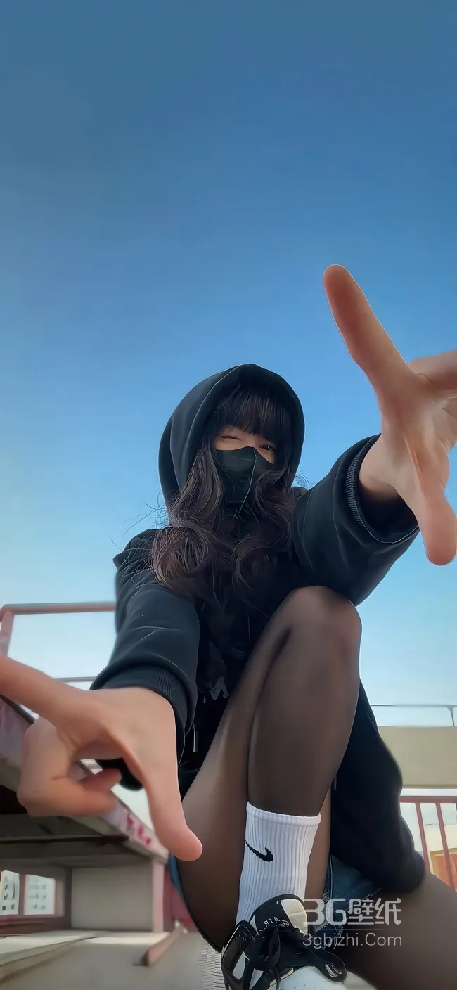 半蹲在地上，身着黑色卫衣，牛仔裤的酷飒女生手势手机壁纸图片1