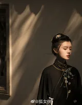 古风美女身着黑色汉服，执纸扇，画风风雅。