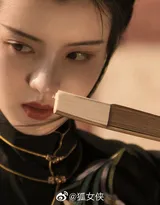 古风美女身着黑色汉服，执纸扇，画风风雅。