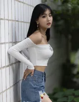 公园一角，穿着时尚的丰满美女，紧身抹胸衣搭配牛仔短裤