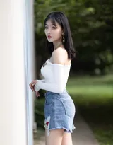 公园一角，穿着时尚的丰满美女，紧身抹胸衣搭配牛仔短裤