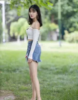 公园一角，穿着时尚的丰满美女，紧身抹胸衣搭配牛仔短裤