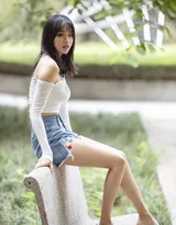 公园一角，穿着时尚的丰满美女，紧身抹胸衣搭配牛仔短裤