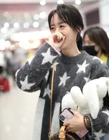 袁冰妍五角星图案带绒毛衣现身机场，手抱玩偶表情丰富