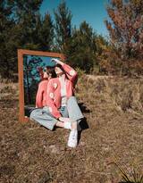 穿着三叶草粉色毛衣牛仔裤欧美美女户外和一面镜子合拍个性另类写真图片