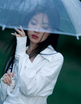 歌手单依纯雨后户外青草地写真，白裙加高筒靴显高挑身材忧郁气质