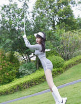 打高尔夫球的凹凸有致身材美女模特儿浅灰运动套装着身户外写真照
